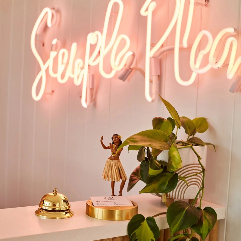 Reception desk with tropical plant and neon sign